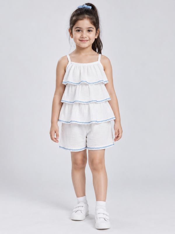 Front view of girls white cotton muslin tiered top and shorts with light-blue zigzag embroidered edging